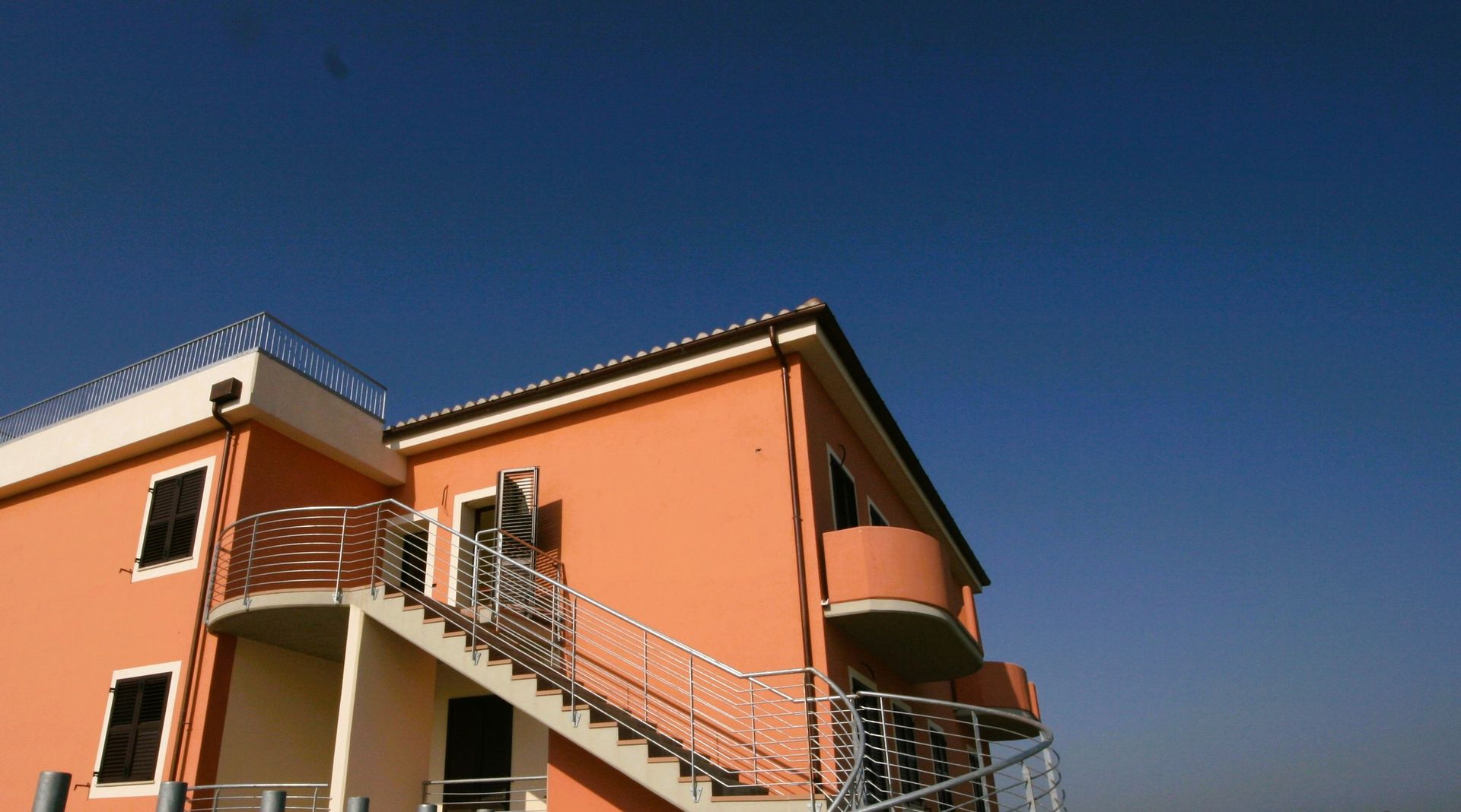 Esempio di riconversione da scuola in appartamenti: foto edificio con intonaco colore rosa